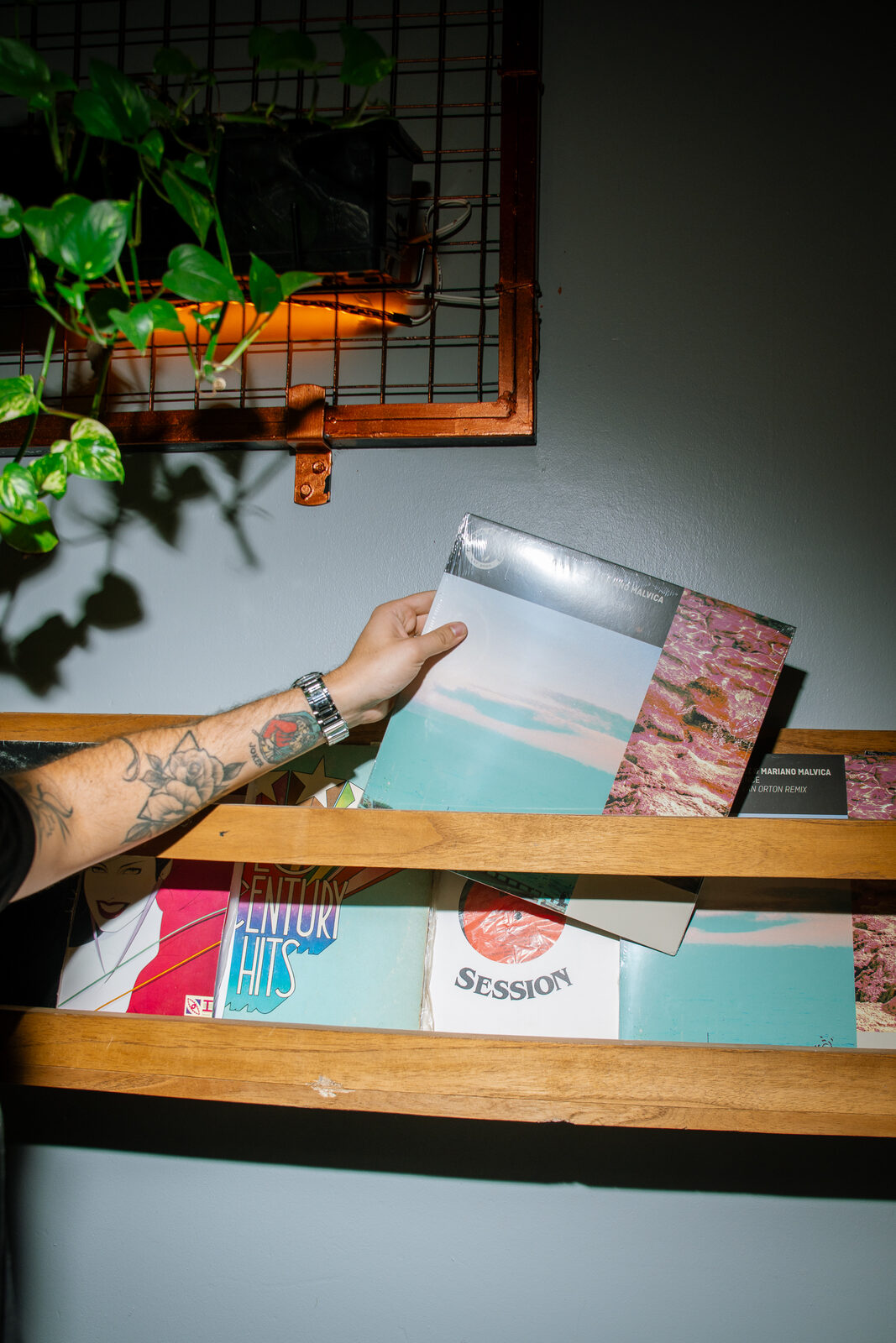 Mano eligiendo un vinilo en el estante